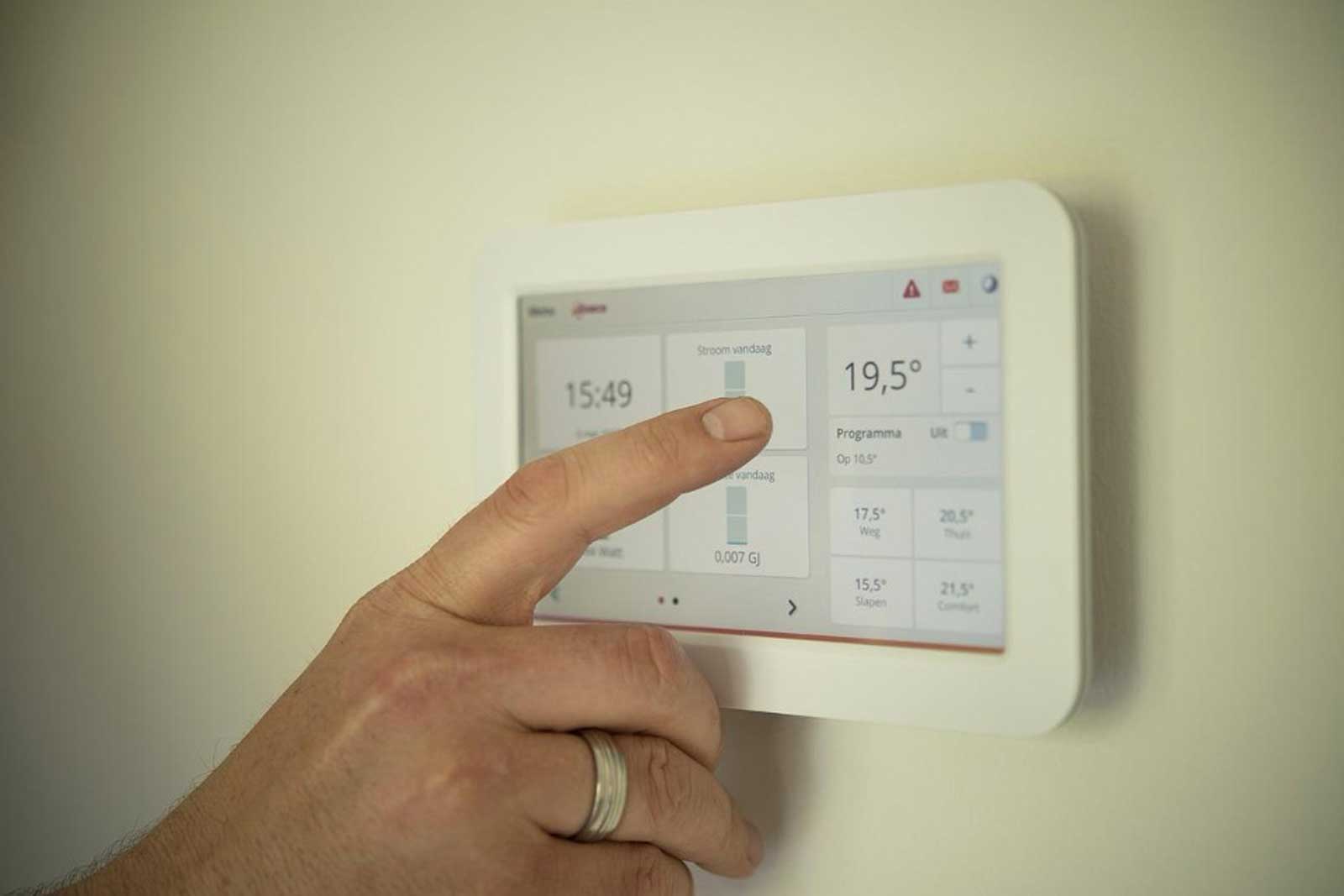 Eine ältere Person reguliert die Temperatur mit einem digitalen Gerät.